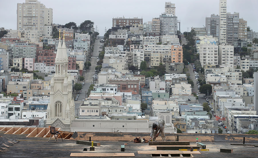 Construction worker operating machinery, possibly a bulldozer or excavator, on a construction site.