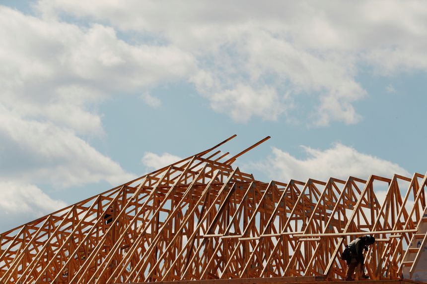Construction workers on a scaffold working on the exterior of a building.