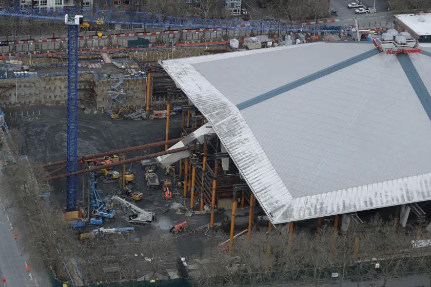 Construction site with heavy equipment, possibly an excavator or loader, moving earth.